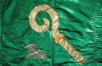 grüne Flagge mit goldenem Hirtenstab und liegendem Lamm